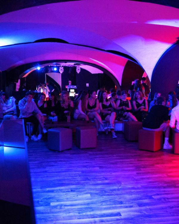 Lounge und Tanzfläche unter dem violett beleuchteten Gewölbe
